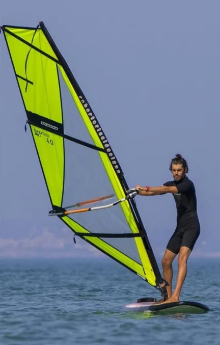 Clase de windsurf en el agua con vela y tabla