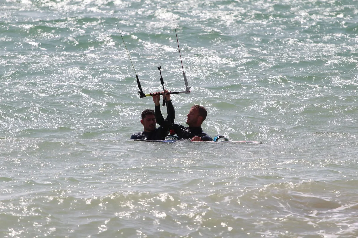 Clase de kitesurf en el agua con instructor y alumno